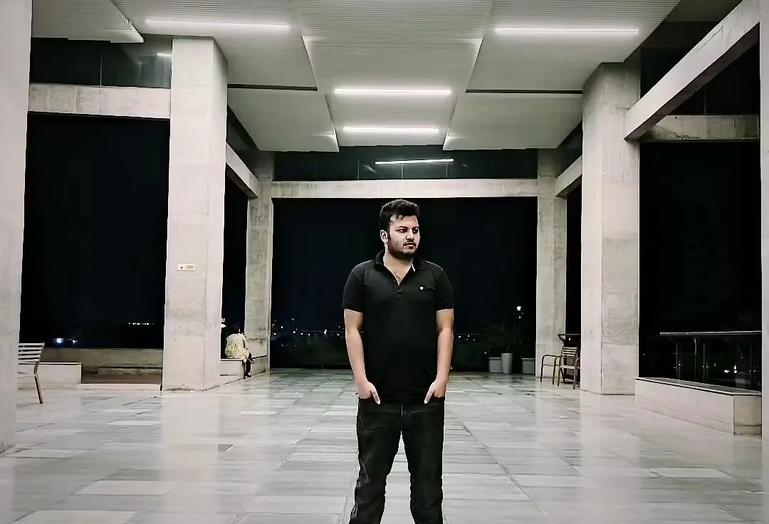 Asif Rezan standing inside modern architecture at night